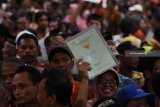 Warga menunjukan sertifikat tanah miliknya saat penyerahan sertifikat tanah untuk rakyat di Surabaya, Kamis (6/9). Pemerintah menargetkan menyerahkan sertifikat tanah sebanyak 7 juta sertifikat tanah untuk rakyat selama 2018. Antara Jatim/Zabur Karuru/18