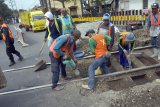 Pekerja melakukan aktivitas perbaikan jalur rel kereta api di titik perlintasan KA Bago, Tulungagung, Jawa Timur, Kamis (20/9). Perbaikan jalur rel itu bertujuan menyeimbangkan geometri kedua sisi badan rel untuk menambah kecepatan rata-rata laju kereta api yang melintas, dari sebelumnya di kisaran 70-80 km/jam menjadi 90 km/jam. Antara Jatim/Destyan Sujarwoko/mas/18.