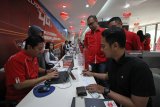 EVP Telkomsel Area Jawa Bali Agus Setia Budi (kiri) melayani pelanggan di GraPARI jalan Pemuda, Surabaya, Jawa Timur, Selasa (4/9). Menyambut Hari Pelanggan Nasional Telkomsel memberikan kejutan berupa hadiah langsung seperti 