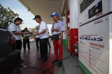 GM Pertamina MOR V Ibnu Chouldum (kedua kanan) memberikan hadiah kepada pelanggan Vi-Gas saat melakukan pengisian di SPBU Jemursari, Surabaya, Jawa Timur, Selasa (4/9). PT Pertamina (persero) memperingati Hari Pelanggan Nasional dengan membagikan 