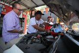 GM Pertamina MOR V Ibnu Chouldum (kedua kiri) mengisi minyak pelumas pada mobil pelanggan di SPBU Jemursari, Surabaya, Jawa Timur, Selasa (4/9). PT Pertamina (persero) memperingati Hari Pelanggan Nasional dengan membagikan 