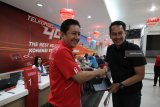 EVP Telkomsel Area Jawa Bali Agus Setia Budi (kiri) memberikan hadiah kepada pelanggan yang beruntung di Surabaya, Jawa Timur, Selasa (4/9). Menyambut Hari Pelanggan Nasional Telkomsel memberikan kejutan berupa hadiah langsung seperti 