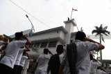 Warga memberi hormat bendera Merah Putih yang berkibar di Hotel Majapahit saat teatrikal peristiwa perobekan bendera di Hotel Yamato sekarang Hotel Majapahit di Jalan Tunjungan, Surabaya, Jawa Timur, Rabu (19/9). Kegiatan tersebut dalam rangka memperingati peristiwa perobekan bendera Belanda menjadi bendera Indonesia pada 19 September 1945 lalu. Antara Jatim/Zabur Karuru/18