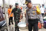 Kapolres Situbondo AKBP Awan Hariono (kanan), Dandim 0823 Situbondo Lektol Inf Akhmad Juni Toa (kiri), menyalurkan air bersih di Desa Jatisari, Arjasa, Situbondo, Jawa Timur, Rabu (19/9). Polres Situbondo membantu penyaluran di Desa Jatisari yang sudah lima bulan kesulitan air bersih di musim kemarau akibat pipa air bersih desa tersebut rusak. Antara Jatim/Seno/mas/18.