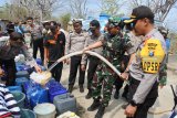 Kapolres Situbondo AKBP Awan Hariono (kanan), Dandim 0823 Situbondo Lektol Inf Akhmad Juni Toa (kedua kanan), menyalurkan air bersih di Desa Jatisari, Arjasa, Situbondo, Jawa Timur, Rabu (19/9). Polres Situbondo membantu penyaluran di Desa Jatisari yang sudah lima bulan kesulitan air bersih di musim kemarau akibat pipa air bersih desa tersebut rusak. Antara Jatim/Seno/mas/18.