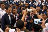 Presiden Joko Widodo (kiri) berfoto bersama mahasiswa usai menyampaikan materi saat kuliah umum wawasan kebangsaan dan membuka rapat kerja nasional (rakernas) lembaga pendidikan Persatuan Guru Republik Indonesia (PGRI) di Universitas PGRI Adi Buana Surabaya, Jawa Timur, Kamis (6/9/2018). ANTARA FOTO/M Risyal Hidayat/pras.