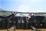 Pekerja membakar batok kelapa di dalam tong untuk dijadikan arang di Rancakiray, Tasikmalaya, Jawa Barat, Kamis (20/9). Dalam sehari perajin setempat memproduksi tujuh kuintal limbah batok kelapa dengan harga jual arang batok Rp8.000 per kilogram yang dipasarkan ke berbagai daerah di Pringan Timur. ANTARA JABAR/Adeng Bustomi/agr/18.
