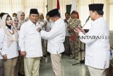 Ketua Umum Gerindra Prabowo Subianto (kanan) menyaksikan penyematan tanda partai dari Ketua DPD Gerindra Jabar yang lama Mulyadi (kedua kanan) kepada Ketua DPD Gerindra Jabar terpilih Brigjen TNI (purn) Taufik Hidayat (ketiga kanan) saat serah terima jabatan ketua DPD Gerindra Jabar di Bandung, Jawa Barat, Rabu (19/9). Prabowo Subianto mengganti Ketua DPD Gerindra Jabar Mulyadi dengan Brigjen TNI (purn) Taufik Hidayat jelang Pileg dan Pilpres 2019. ANTARA JABAR/M Agung Rajasa/agr/18