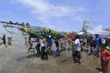 Warga membawa replika ikan untuk di larung ke laut saat acara Syukur Pesisir di Karangsong, Indramayu, Jawa Barat, Minggu (16/9). Kegiatan yang digelar para petambak ikan bandeng dan udang tersebut sebagai bentuk syukur kepada Sang Pencipta atas hasil panen yang mereka peroleh. ANTARA JABAR/Dedhez Anggara/agr/18.