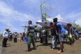 Warga membawa replika ikan untuk di larung ke laut saat acara Syukur Pesisir di Karangsong, Indramayu, Jawa Barat, Minggu (16/9). Kegiatan yang digelar para petambak ikan bandeng dan udang tersebut sebagai bentuk syukur kepada Sang Pencipta atas hasil panen yang mereka peroleh. ANTARA JABAR/Dedhez Anggara/agr/18.