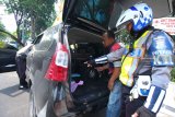 Polisi memeriksa barang bawaaan kendaraan bermotor milik warga yang terjaring razia di Jalan Panglima Sudirman, Surabaya, Jawa Timur, Jumat (21/9). Razia yang digelar Satlantas Polrestabes Surabaya itu selain memeriksa surat kelengkapan kendaraan bermotor juga dilakukan tes urine atau narkoba bagi pengendaranya dengan tujuan meminimalisir terjadinya kecelakaan lalulintas. Antara Jatim/Didik Suhartono/mas/18.