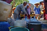 Sejumlah warga bergantian mengisi air bantuan bencana kekeringan di Desa Kawengen, Ungaran Timur, Kabupaten Semarang, Jawa Tengah, Selasa (18/9/2018). Kemarau panjang di Kabupaten Semarang telah menyebabkan krisis air warga di sembilan kecamatan dan puluhan desa.  (ANTARA FOTO/Aditya Pradana Putra)