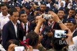 Presiden Joko Widodo (kiri) berfoto bersama mahasiswa usai menyampaikan materi dalam kuliah umum wawasan kebangsaan dan membuka rapat kerja nasional (rakernas) lembaga pendidikan Persatuan Guru Republik Indonesia (PGRI) di Universitas PGRI Adi Buana Surabaya, Jawa Tmur, Kamis (6/9). ANTARA FOTO/M Risyal Hidayat/wdy/2018.