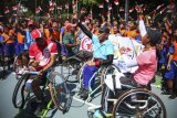 Sejumlah siswa SD Manahan bernyanyi bersama atlet National Paralympic Committee (NPC) cabang tenis kursi roda saat pemusatan latihan Asian Para Games 2018 di Lapangan Tenis Manahan, Solo, Jawa Tengah, Jumat (28/9). Aksi para siswa tersebut untuk mendukung para atlet yang berlaga pada ajang Asian Para Games 2018 di Jakarta. ANTARA FOTO/Maulana Surya/foc/18.
