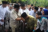 Ketua umum Partai Gerindra Prabowo Subianto (ke dua kiri) menyalami warga saat akan melakukan ziarah ke makam Syaikhona Kholil di Bangkalan, Jawa Timur, Kamis (6/9). Sebelumnya Prabowo juga melakukan ziarah ke makam pendiri NU KH Hasyim Asy'ari  dan makam KH Wahid Hasyim serta KH Abdurrahman Wahid atau Gus Dur di  Jombang. Antara Jatim/Saiful Bahri/mas/18.