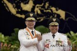 Gubernur Jawa Barat Ridwan Kamil (kiri) bersama Wakil Gubernur Uu Ruzhanul Ulum (kanan) berjabat tangan usai pelantikan di Istana Negara, Jakarta, Rabu (5/9). Presiden melantik sembilan kepala daerah hasil dari Pilkada serentak 2018, yaitu Papua, NTT, Jawa Tengah, Sumatera Utara, Bali, Jawa Barat, Kalimantan Barat, Sulawesi Selatan, dan Sulawesi Tenggara. ANTARA JABAR/Puspa Perwitasari/agr/18
