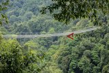 Pengunjung berjalan melintasi jembatan gantung Situ Gunung di Taman Nasional Gunung Gede Pangrango (TNGGP) Resort Situgunung, Kabupaten Sukabumi, Jawa Barat, Jumat (21/9). Jembatan gantung yang memiliki panjang mencapai 243 meter, lebar 2 meter dan dari permukaan tanah dan tinggi mencapai 161 meter tersebut merupakan jembatan gantung terpanjang di Asia. ANTARA JABAR/Nurul Ramadhan/agr/18