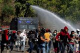 Polisi menyemprotkan air ke pengunjuk rasa dengan meriam air (water cannon) pada simulasi pengamanan Pemilu 2019 di Lapangan Bhayangkara Kompleks Akademi Kepolisian (Akpol) Semarang, Jawa Tengah, Selasa (18/9/2018). Dalam simulasi yang melibatkan sekitar 2.000 personel dari berbagai instansi itu diperagakan berbagai tindakan untuk pengamanan VIP, kampanye, dan penanganan unjuk rasa anarkis. (ANTARA FOTO/R. Rekotomo)