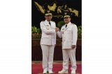 Gubernur Kalimatan Barat Sutarmidji (kiri) bersama Wakil Gubernur Ria Norsan (kanan) melakukan salam komando usai pelantikan di Istana Negara, Jakarta, Rabu (5/9). Presiden melantik sembilan gubernur dan wakil gubernur hasil Pilkada serentak 2018, yaitu Papua, NTT, Jawa Tengah, Sumatera Utara, Bali, Jawa Barat, Kalimantan Barat, Sulawesi Selatan, dan Sulawesi Tenggara. ANTARA FOTO/Puspa Perwitasari/aww/18.