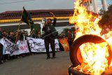 Puluhan mahasiswa yang tergabung dalam Aliansi Mahasiswa Universitas Sumatera Utara (USU) berunjuk rasa dengan membakar ban bekas di depan kampus mereka, di Medan, Sumatra Utara, Kamis (27/9). Mereka mendesak agar kasus pemukulan yang dialami rekan mereka saat berunjuk rasa mengkritisi pemerintah yang berakhir bentrok di depan gedung DPRD Sumut pada Kamis (20/9) segera diusut tuntas. ANTARA FOTO/Irsan Mulyadi/kye/18.
