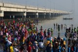 Pelajar memungut sampah saat mengikuti aksi Bersih-Bersih Pantai Jembatan Suramadu, Surabaya, Jawa Timur, Minggu (30/9). Aksi ribuan pelajar tersebut sebagai wujud kepedulian terhadap kebersihan lingkungan di kawasan yang merupakan salah satu ikon wisata di Surabaya. Antara Jatim/Didik Suhartono/mas/18.