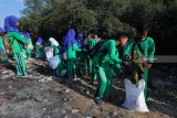 Pelajar memungut sampah saat mengikuti aksi Bersih-Bersih Pantai Jembatan Suramadu, Surabaya, Jawa Timur, Minggu (30/9). Aksi ribuan pelajar tersebut sebagai wujud kepedulian terhadap kebersihan lingkungan di kawasan yang merupakan salah satu ikon wisata di Surabaya. Antara Jatim/Didik Suhartono/mas/18.