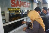 Pemilik kendaraan antre membayar pajak saat Program Pemutihan Pajak Kendaraan Bermotor di Samsat Corner di Alun-alun Malang, Jawa Timur, Senin (8/10). Program yang berlangsung selama 68 hari tersebut diadakan Pemprov Jatim untuk mendorong masyarakat memenuhi kewajibannya membayar pajak sekaligus mengoptimalisasikan semua jenis layanan Samsat sehingga diharapkan mampu meningkatkan pendapatan daerah. Antara Jatim/Ari Bowo Sucipto/mas/18.