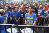 Suporter kesebelasan Arema FC (Aremania) memberi dukungan pada tim kesayangannya di luar stadion saat bertanding melawan Bali United di Stadion Kanjuruhan, Malang, Jawa Timur, Sabtu (20/10/2018). Komisi Disiplin (Komdis) PSSI menjatuhi sanksi untuk Arema FC yakni menggelar pertandingan tanpa penonton hingga akhir musim kompetisi Liga I GOJEK pasca rusuh suporter saat pertandingan Arema melawan Persebaya pada tanggal 6 Oktober 2018 lalu. Antara Jatim/Ari Bowo Sucipto/ZK. 