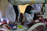 Dokter memeriksa kesehatan warga saat bakti sosial layanan kereta kesehatan (rail clinic) dan kereta perpustakaan (rail library) di Stasiun Randuagung, Lumajang, Jawa Timur, Rabu (3/10). PT KAI Daop 9 Jember melakukan pemeriksaan kesehatan dan pengobatan gratis, untuk menjangkau daerah-daerah terpencil di sekitar jalur kereta api, sehingga dapat memberikan manfaat bagi masyarakat. Antara Jatim/Seno/mas/18. 