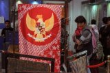 Pengunjung mengamati koleksi batik di Museum Batik, Pekalongan, Jawa Tengah, Selasa (16/10/2018). Museum Batik Pekalongan menambah koleksi batik dengan memproduksi batik motif Garuda Pancasila sebagai lambang negara yang bermakna Bhinneka Tunggal Ika yang menunjukkan sejarah perkembangan batik nusantara yang terbentuk dari ragam berbagai budaya. ANTARA FOTO/Harviyan Perdana Putra/wdy/2018