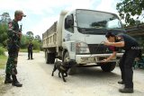 Seorang petugas dan anjing pelacak dari Unit K9 Bea Cukai Kantor Wilayah Kalimantan Bagian Barat (Kanwil) Kalbagbar memeriksa kendaraan dari Malaysia yang hendak masuk ke Indonesia di perbatasan Jagoi Babang, Kabupaten Bengkayang, Kalbar, Rabu (17/10/2018). Guna mengantisipasi penyelundupan narkoba, Unit K9 Bea Cukai Kanwil Kalbagbar melakukan pemeriksaan dengan mengunakan anjing pelacak yang mampu mendeteksi keberadaan barang ilegal tersebut. ANTARA FOTO/HS Putra/jhw