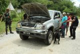 Seorang petugas dan anjing pelacak dari Unit K9 Bea Cukai Kantor Wilayah Kalimantan Bagian Barat (Kanwil) Kalbagbar memeriksa kendaraan dari Malaysia yang hendak masuk ke Indonesia di perbatasan Jagoi Babang, Kabupaten Bengkayang, Kalbar, Rabu (17/10/2018). Guna mengantisipasi penyelundupan narkoba, Unit K9 Bea Cukai Kanwil Kalbagbar melakukan pemeriksaan dengan mengunakan anjing pelacak yang mampu mendeteksi keberadaan barang ilegal tersebut. ANTARA FOTO/HS Putra/jhw