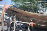 Pekerja menyelesaikan pembuatan kapal kayu, di Pelabuhan Tanglok, Sampang, Jatim, Selasa (2/10). Pembuatan kapal kayu dengan ukuran 20x6 meter itu menghabiskan dana  sekitar Rp500 juta. Tingginya biaya produksi tersebut karena susahnya mendaptkan kayu berkualitas. Antara Jatim/Saiful Bahri/mas/18.