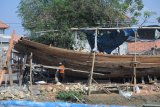 Pekerja menyelesaikan pembuatan kapal kayu, di Pelabuhan Tanglok, Sampang, Jatim, Selasa (2/10). Pembuatan kapal kayu dengan ukuran 20x6 meter itu menghabiskan dana  sekitar Rp500 juta. Tingginya biaya produksi tersebut karena susahnya mendaptkan kayu berkualitas. Antara Jatim/Saiful Bahri/mas/18.