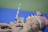 Seorang bidan menyiapkan suntikan yang berisi vaksin DPT saat mengadakan imunisasi di Rancamaya, Kabupaten Bogor, Jawa Barat, Kamis (25/10/2018). Data dari Kementerian Kesehatan mencatat bahwa selama lima tahun terakhir, cakupan imunisasi dasar lengkap tidak selalu menunjukkan hasil optimal. Cakupan imunisasi yang melebihi target hanya terjadi pada tahun 2013 dan 2016. ANTARA JABAR/Raisan Al Farisi/agr.