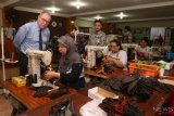 Head of Economic Cooperation and Development Divition and Delegate of the Swiss Government for Trade Agreements Ambassador Raymund Furrer (kiri) mengamati pembuatan sandal di Kelompok Usaha Bersama (KUB) Mampu Jaya di Surabaya, Jawa Timur, Rabu (17/10/2018). Kunjungan sejumlah delegasi Swiss itu untuk melihat secara langsung tempat produksi berbagai sandal dan sepatu kulit di kawasan bekas lokalisasi Dolly di Surabaya itu. ANTARA FOTO/Didik Suhartono/foc.