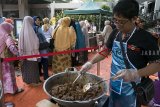 Warga mengantre untuk membeli nasi rendang yang dibayar seikhlasnya di Halaman Masjid Salman ITB, Bandung, Jawa Barat, Jumat (19/10/2018). Kegiatan yang dijadwalkan tiap hari Jumat tersebut bertujuan untuk menambah donasi dan bantuan dari gerakan pengiriman satu ton Rendang Yayasan Rumah Amal Salman untuk korban bencana di Palu dan Donggala, Sulawesi Tengah. ANTARA JABAR/Novrian Arbi/agr.