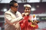 Menpora Imam Nahrawi (kiri) dan Atlet Indonesia Rica Oktavia (kanan) berpose seusai penyerahan medali para atletik nomor lompat jauh putri T20 Asian Para Games 2018 di Stadion Utama GBK, Jakarta, Senin (8/10/2018). Rica Oktavia meraih medali emas dengan lompatan 5,25 meter diikuti Siti Noor Radiah sejauh 5,18 meter dan Sakai Sonomi sejauh 5,02 meter. ANTARA FOTO/Dhemas Reviyanto/ama