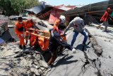 Anggota Basarnas mengevakuasi jenazah korban gempa di Petabo, Palu Selatan, Sulawesi Tengah, Senin (1/10/2018). ANTARA FOTO/Akbar Tado/foc. 