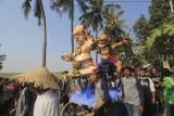 Warga mengarak patung berbentuk tokoh pewayangan dan Memedi Raksasa saat Festival Memedi di desa Gadingan, Sliyeg, Indramayu, Jawa Barat, Rabu (24/10). Festival Memedi tersebut digelar dalam rangka tradisi Ngunjung Buyut Gading yang merupakan tradisi masyarakat setempat untuk mengunjungi makam leluhur usai masa panen. ANTARA JABAR/Dedhez Anggara/agr.
