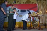 Menteri Koordinator Bidang Politik Hukum dan Keamanan (Menko Polhukam) Wiranto (kanan) memukul gong membuka Forum Komunikasi dan Sinkronisasi Kesadaran Bela Negara disaksikan Kasdam V Brawijaya, Brigjen TNI Widodo Iryansyah (kedua kiri), Kepala Badan Kesatuan Bangsa dan Politik (Bakesbangpol) Jawa Timur, Jonathan Judianto (kiri) di Hotel Utami Juanda, Sidoarjo, Jawa Timur, Senin (29/10/2018). Forum yang diikuti sejumlah TNI POLRI tersebut mengambil tema 'Sosialisasi Inpres Nomor 7 Tahun 2018 tentang Rencana Aksi Nasional Bela Negara Tahun 2018-2019'. Antara Jatim/Umarul Faruq/ZK