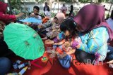 Peserta melukis payung saat peringatan Hari Cerebral Palsy Sedunia di Surabaya, Jawa Timur, Minggu (7/10). Peringatan Hari Cerebral Palsy Sedunia yang diisi dengan kegiatan membatik, melukis payung dan menggambar bersama tersebut diikuti 750 penyandang disabilitas dengan mengusung tema 