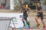 Atlet Triathlon Eva Desiana (kiri) dan pembalap Rio Haryanto (kanan) mengikuti Herbalife Bali International Triathlon 2018 di Sanur, Denpasar, Bali, Minggu (21/10/2018). Herbalife Bali International Triathlon 2018 diikuti 2.250 orang peserta dari berbagai negara, terbagi dalam tiga kategori utama yaitu, Olympic Distance Course (renang 1,5 km, sepeda 40 km, lari 10 km), Sprint Distance Course (renang 500m, sepeda 20 km, lari 5 km) dan 5 km Fun Run. ANTARA FOTO/Fikri Yusuf/pd