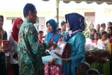 Bupati Tanah Laut H Sukamta menyerahkan penghargaan kepada dua peserta Keluarga Penerima Manfaat (KPM) dan hadiah kepada enam anak berprestasi, pemenang lomba Cerdas Cermat, lomba masakan ikan serta pemberian susu formula, di desa Asam-Asam, Kamis (11/10).Foto:Antaranews Kalsel/Arianto/f.