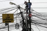 Pekerja melakukan pemasangan kabel telekomunikasi di kawasan Cikeas, Bogor, Jawa Barat, Selasa (16/10/2018). Kesemrawutan penataan instalasi kabel listrik dan telekomunikasi yang saling tumpang tindih menyebabkan berkurangnya keindahan tata ruang kota. ANTARA JABAR/Yulius Satria Wijaya/agr.