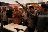 Menteri Perdagangan Enggartiasto Lukita (ketiga kiri) dan Gubernur Jawa Timur Soekarwo (kedua kanan) mencoba produk senapan angin di salah satu stan pameran saat Jatim Fair 2018 di Surabaya, Jawa Timur, Selasa (9/10). Pameran yang digelar hingga 14 Oktober 2018 tersebut diikuti sebanyak 531 stan produk unggulan dalam rangka HUT ke-73 Provinsi Jawa Timur. Antara Jatim/Moch Asim/18.