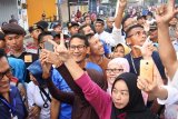 Calon wakil presiden nomor urut 02 Sandiaga Uno berfoto bersama warga di Pasar Tanjung, Jember, Jawa Timur, Minggu (7/10/2018). Sandiaga Uno yang berpasangan dengan Prabowo Subianto berkampanye mengunjungi Pasar Tanjung Jember, berdialog dengan relawan dan wargai di Roemah Djoeang Prabowo - Sandi. ANTARA FOTO/Seno/pras.