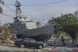 Warga berada di dekat kapal TNI AL yang terdampar di jalanan akibat gempa dan tsunami, di Watusampu, Ulujadi, Palu, Sulawesi Tengah, Kamis (4/10/2018). ANTARA FOTO/Muhammad Adimaja/kye 