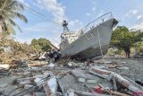 Warga berada di dekat kapal TNI AL yang terdampar di jalanan akibat gempa dan tsunami, di Watusampu, Ulujadi, Palu, Sulawesi Tengah, Kamis (4/10/2018). ANTARA FOTO/Muhammad Adimaja/kye 