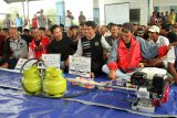 Sejumlah nelayan berkumpul usai menerima bantuan paket konverter kit mesin perahu berbahan bakar gas di Pangkalan Pendaratan Ikan (PPI) Kuala Mempawah di Kabupaten Mempawah, Kalbar, Jumat (12/10). Kementerian ESDM bersama PT Pertamina (persero) menyalurkan bantuan paket konverter kit kepada 306 nelayan kecil dari Kabupaten Mempawah dan Kota Singkawang Kalbar guna mendukung Pemerintah dalam program konversi bbm ke LPG, sekaligus meningkatkan pendapatan nelayan menangkap ikan di laut. ANTARA FOTO/HS Putra/jhw/18
